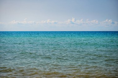 donuk bulutların üstünde güzel bir güneşli gün ile mavi okyanus.