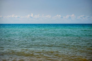 donuk bulutların üstünde güzel bir güneşli gün ile mavi okyanus.