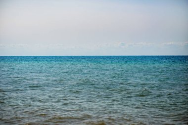 donuk bulutların üstünde güzel bir güneşli gün ile mavi okyanus.