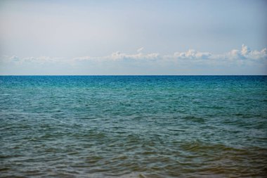 donuk bulutların üstünde güzel bir güneşli gün ile mavi okyanus.