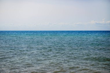 donuk bulutların üstünde güzel bir güneşli gün ile mavi okyanus.