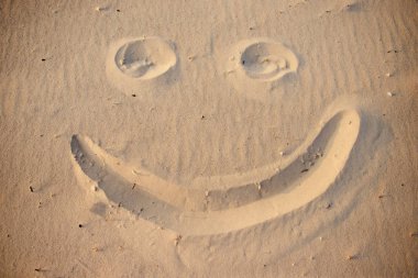 bir kum üzerinde çizim gülen yüz.