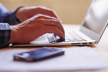 dizüstü bilgisayar kullanan bir işçinin yakın çekim.