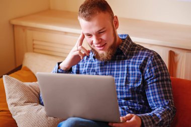 dizüstü bilgisayarınızda evde absorbe çalışan genç adam.