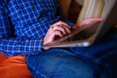 dizüstü bilgisayarınızda evde absorbe çalışan genç adam.