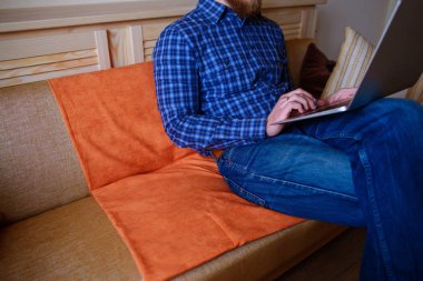 dizüstü bilgisayarınızda evde absorbe çalışan genç adam.