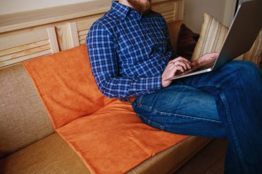 dizüstü bilgisayarınızda evde absorbe çalışan genç adam.