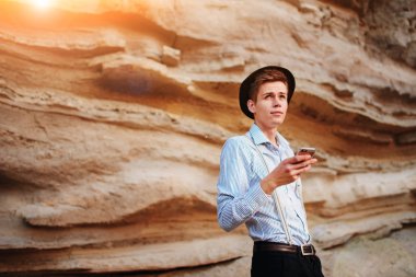 Bir akıllı telefon ekranına bir kum ocağı özgeçmişlerine bakarak çekici bir adam.