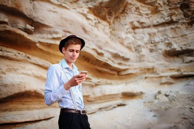 Bir akıllı telefon ekranına bir kum ocağı özgeçmişlerine bakarak çekici bir adam.