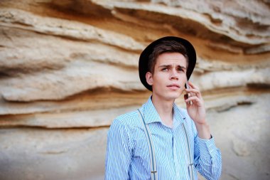 Çekici bir adam bir kum ocağı ortasında duran ve bir akıllı telefon üzerinden arama yapma.