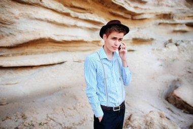 Çekici bir adam bir kum ocağı ortasında duran ve bir akıllı telefon üzerinden arama yapma.