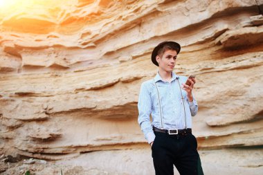 Bir akıllı telefon ekranına bir kum ocağı özgeçmişlerine bakarak çekici bir adam.