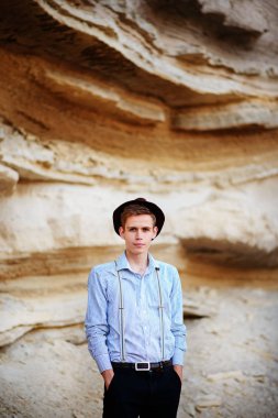 Şık çekici adam bir kum ocağı ortasında duruyor ve kameraya poz veriyor.