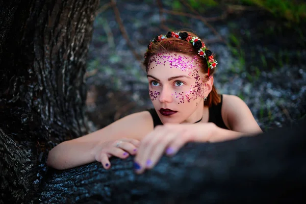 Молода Красива Жінка Фіолетовим Сяйвом Обличчі Сидить Біля Спаленого Дерева — стокове фото