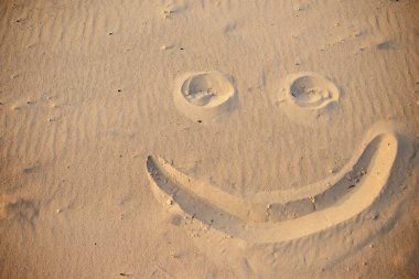 bir kum üzerinde çizim gülen yüz.