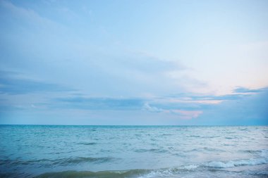 donuk bulutların üstünde güzel bir güneşli gün ile mavi okyanus.