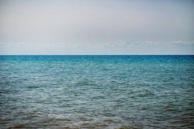 donuk bulutların üstünde güzel bir güneşli gün ile mavi okyanus.