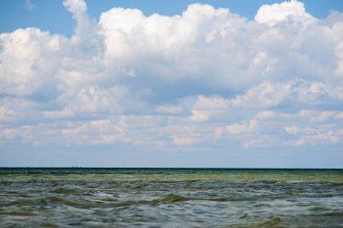 donuk bulutların üstünde güzel bir güneşli gün ile mavi okyanus.