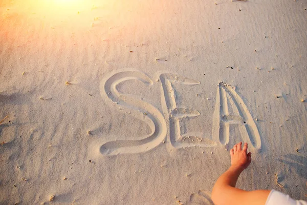 Uma Jovem Escreve Areia Palavra Mar — Fotografia de Stock