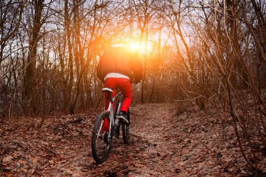 Dağ yolu ormandaki bisiklet sürme sırt çantası olan kadın.