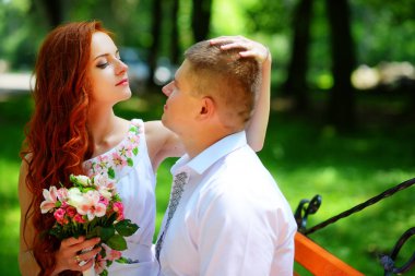 Gelin ve damat bir bankta oturup.