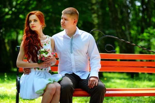 新娘和新郎坐在长椅上 — 图库照片