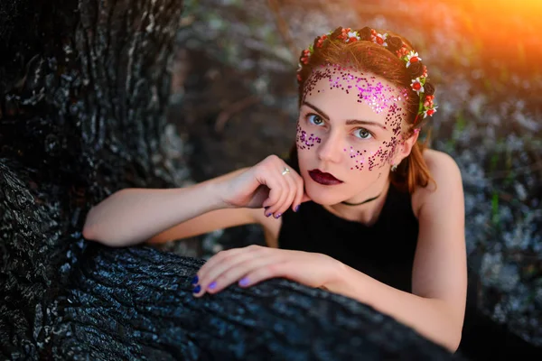 Молода Красива Жінка Фіолетовим Сяйвом Обличчі Сидить Біля Спаленого Дерева — стокове фото