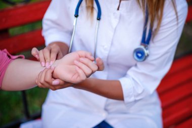 bakan doktor veya Hemşire Genç hastaya açık havada, oturan bir tezgah ve darbe testi alarak.