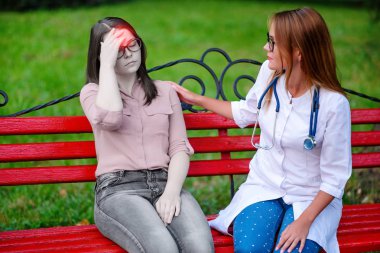 bakan doktor veya Hemşire Genç hastaya açık havada alarak, hasta baş ağrısı hakkında endişeleniyor