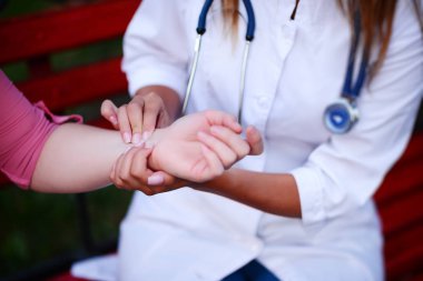 bakan doktor veya Hemşire Genç hastaya açık havada, oturan bir tezgah ve darbe testi alarak.