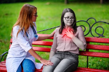 bakan doktor veya Hemşire Genç hastaya açık havada, bir bankta oturan alarak tutun konuşma.