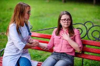 bakan doktor veya Hemşire Genç hastaya açık havada, bir bankta oturan alarak tutun konuşma.