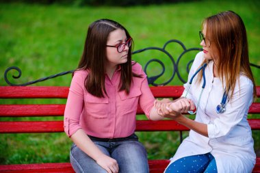 bakan doktor veya Hemşire Genç hastaya açık havada, oturan bir tezgah ve darbe testi alarak.