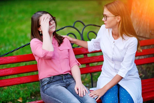 bakan doktor veya Hemşire Genç hastaya açık havada alarak, hasta baş ağrısı hakkında endişeleniyor