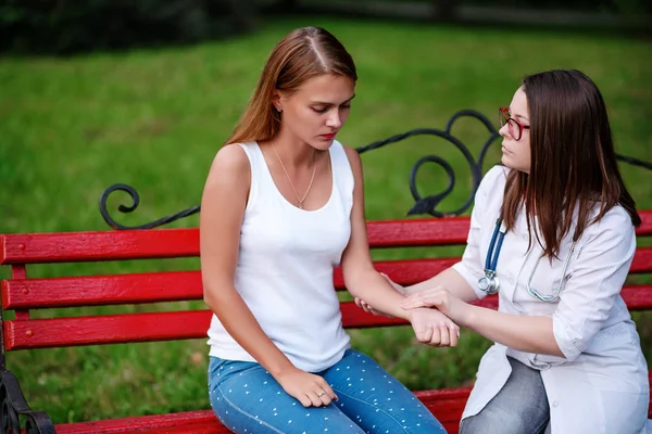bakan doktor veya Hemşire Genç hastaya açık havada, bir bankta oturan alarak tutun konuşma