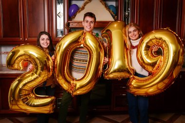 Yeni 2019 yıl geliyor. Gençlerin grup altın taşıyan neşeli numaraları renkli ve partide iyi eğlenceler.