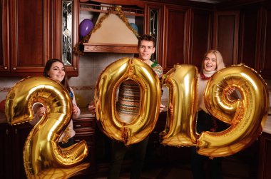 Yeni 2019 yıl geliyor. Gençlerin grup altın taşıyan neşeli numaraları renkli ve partide iyi eğlenceler.