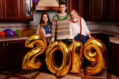 Yeni 2019 yıl geliyor. Gençlerin grup altın taşıyan neşeli numaraları renkli ve partide iyi eğlenceler.