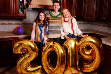 Yeni 2019 yıl geliyor. Gençlerin grup altın taşıyan neşeli numaraları renkli ve partide iyi eğlenceler.