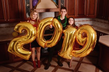 Yeni 2019 yıl geliyor. Gençlerin grup altın taşıyan neşeli numaraları renkli ve partide iyi eğlenceler.