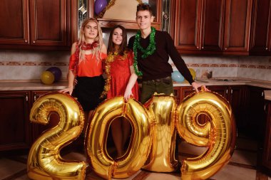 Yeni 2019 yıl geliyor. Gençlerin grup altın taşıyan neşeli numaraları renkli ve partide iyi eğlenceler.