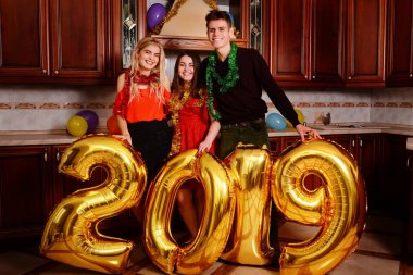 Yeni 2019 yıl geliyor. Gençlerin grup altın taşıyan neşeli numaraları renkli ve partide iyi eğlenceler.