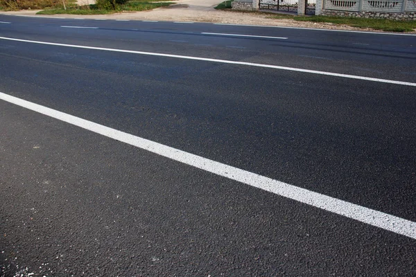 Asphalt road with marking lines white stripes.