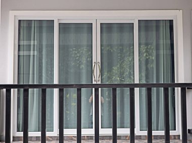 Cam kapılar ve perdelerle kaplı balkon..