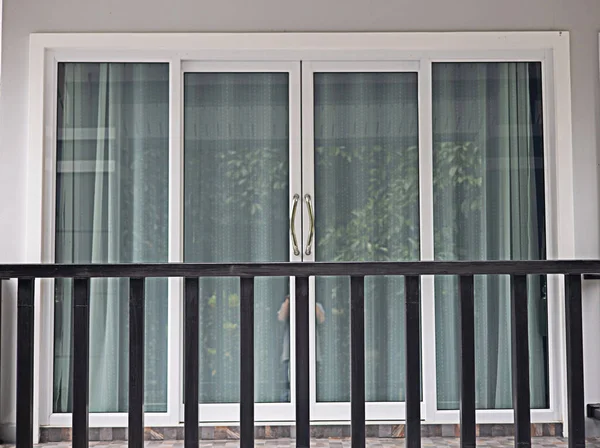 Cam kapılar ve perdelerle kaplı balkon..