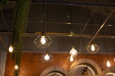 Tavandan sarkan bir sürü eski, parlak ampul var..