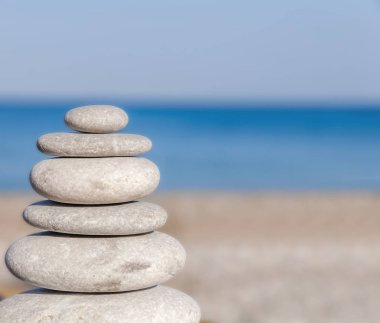 Stres bulanık mavi deniz ve plaj üzerinde birkaç Zen taşları dengeli 