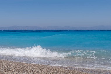 Kadar yakın küçük dalga ve kum çakıl plajı kabarcıkları ile yaz 