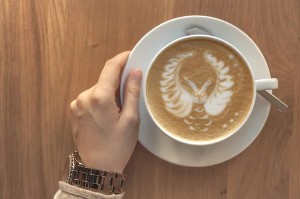 Chica Sosteniendo Una Taza Capuchino Expreso Fresco Una Mesa Madera — Foto de Stock