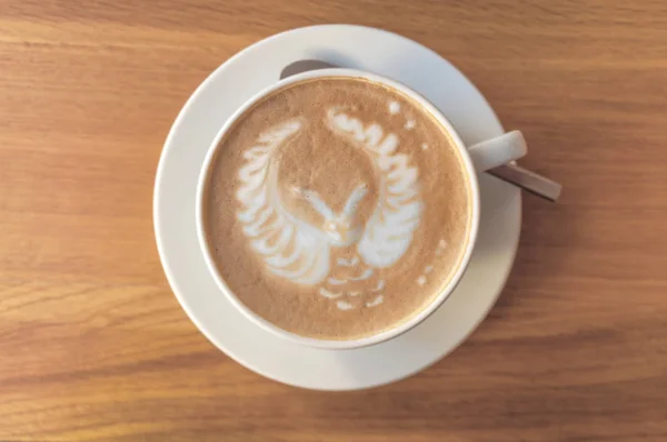 Owl latte art espresso cup cappuccino on a wooden table in cafe shop